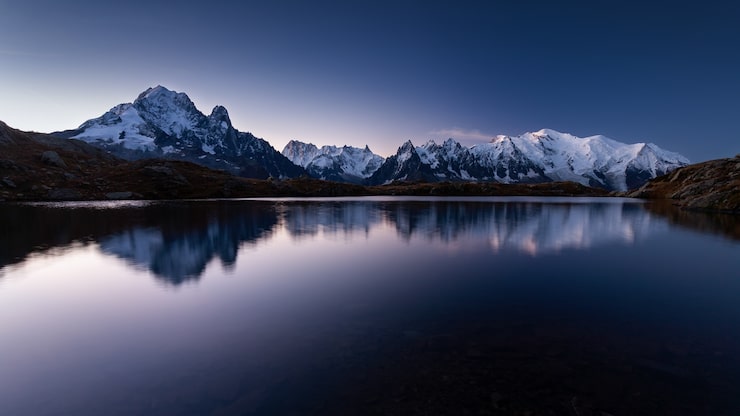 Foto gratuito monte mont blanc cubierto de nieve reflejándose en el agua por la noche en chamonix, francia