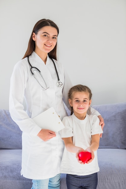 Foto gratuito niña rubia sosteniendo corazón con doctora