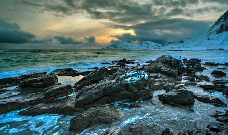 Foto playa del mar de noruega en una costa rocosa al atardecer en invierno
