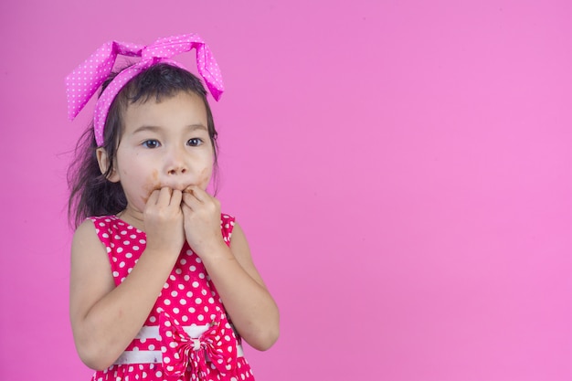 ฟรี Photo สาวน้อยน่ารักใส่เสื้อลายทางสีแดงกินช็อกโกแลตปากเลอะบนสีชมพู