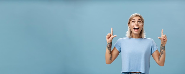 Free Photo studio shot of impressed speechless happy goodlooking woman with tattoos on arms dropping jaw from