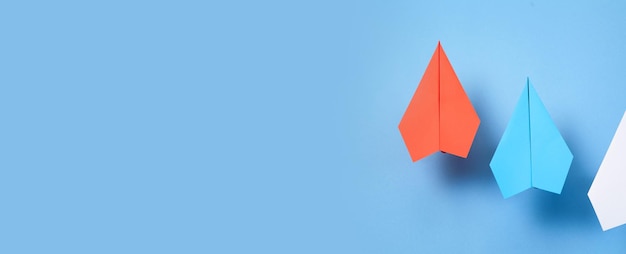 Photo red blue and white paper airplanes on blue background leadership teamwork