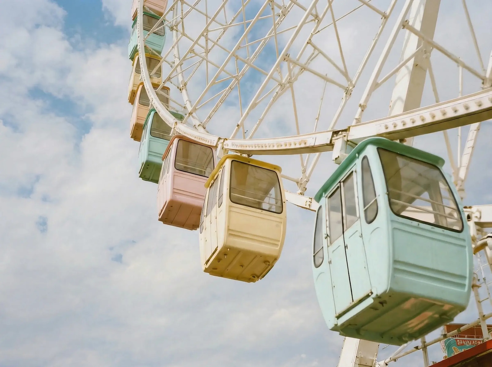 Pastel ferris wheel cabins against a cloudy sky, generated with Kling 2.6 on Magnific