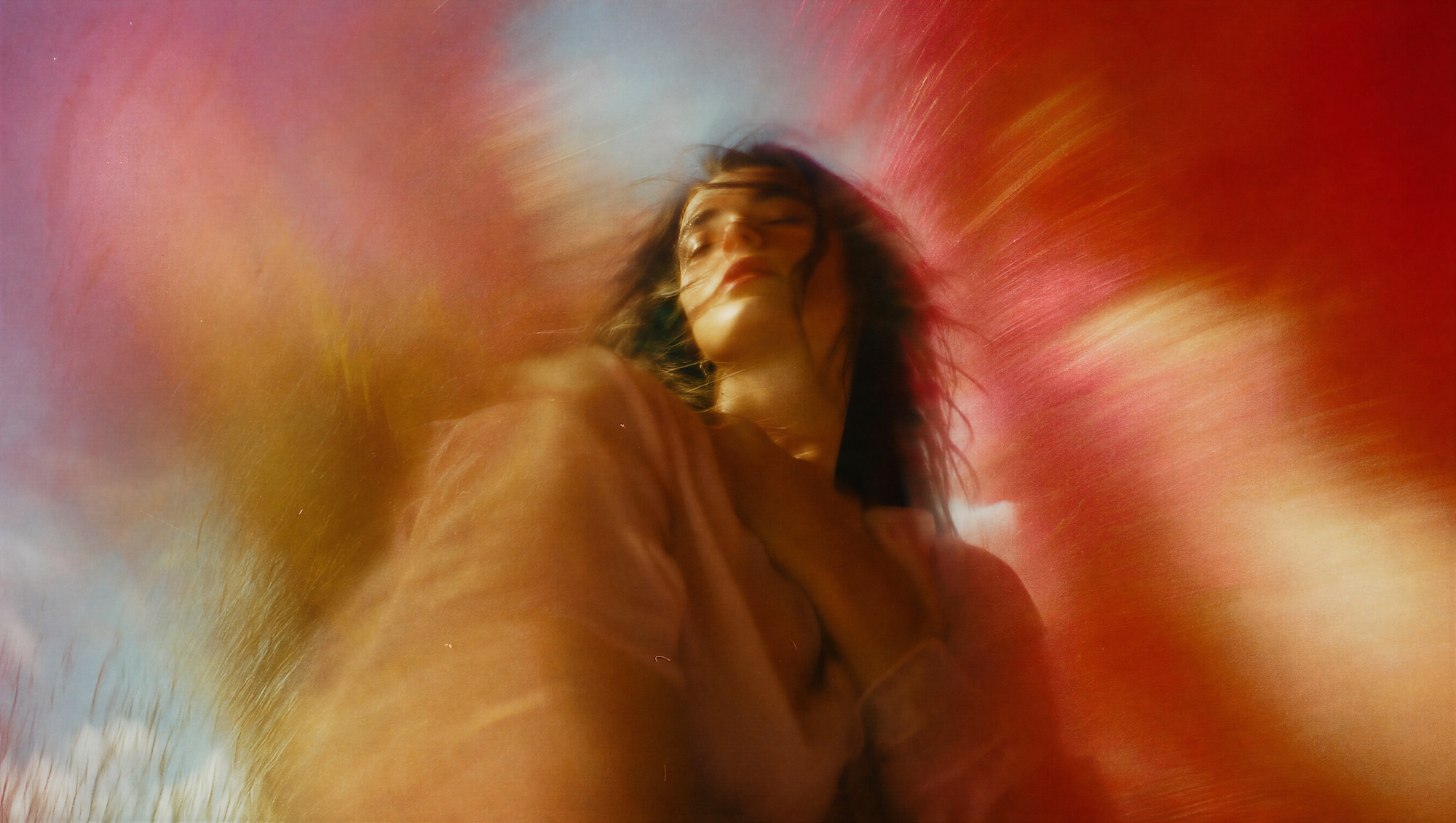 Woman with her eyes closed in a warm red and orange motion blur